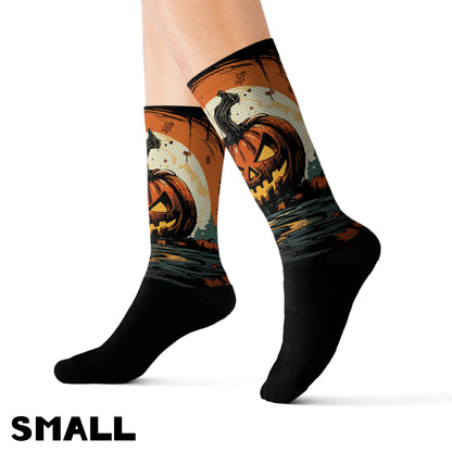 A pair of small-size black alternative fashion jack o lantern Halloween socks on a person's feet.
